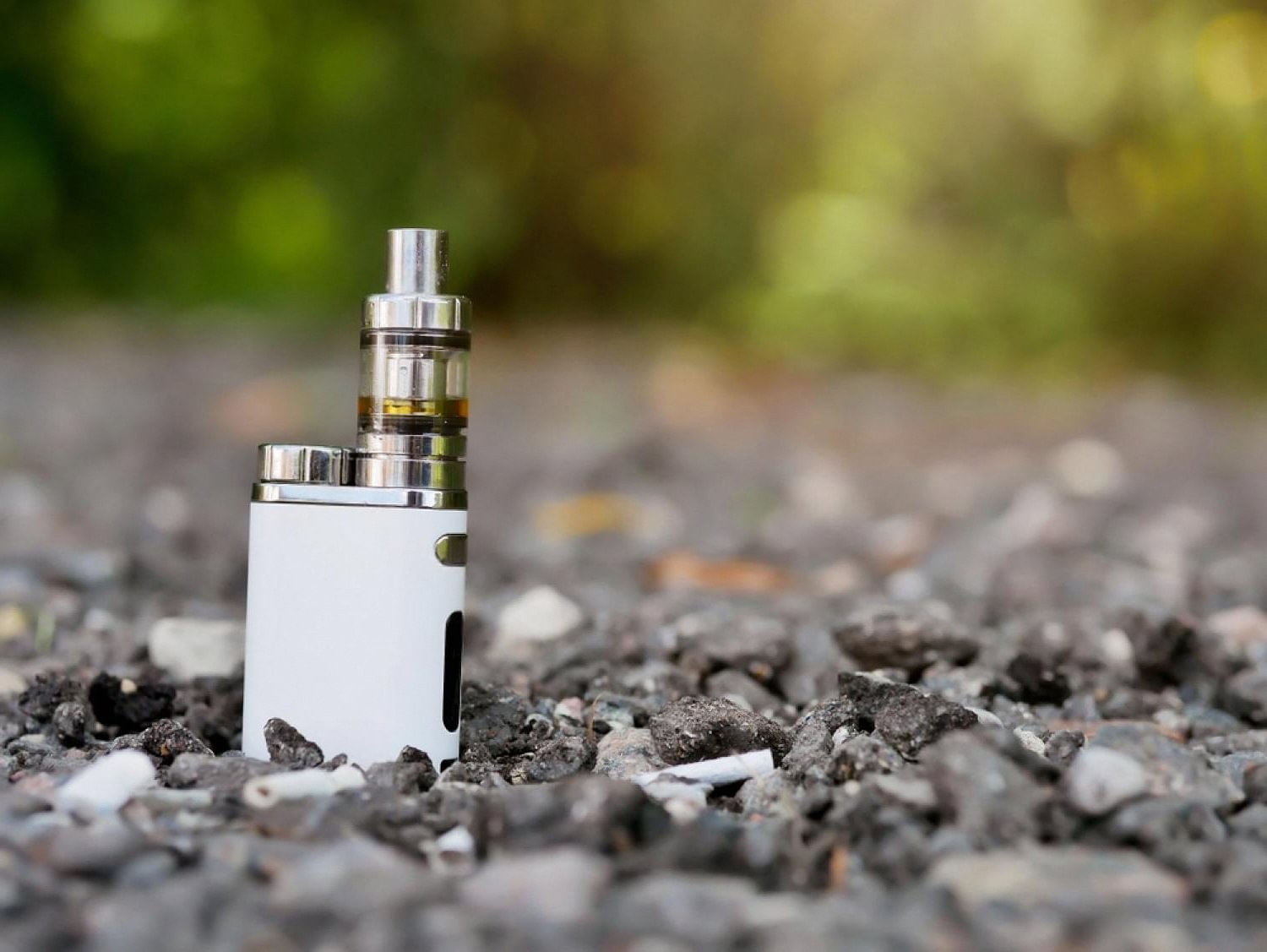 Compact white vape mod with a glass tank showing coil assembly and airflow slot